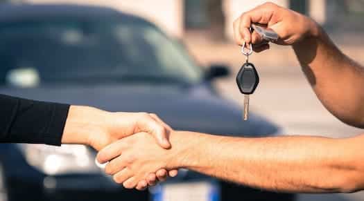 poignée de main et remise de clé après vente de voiture